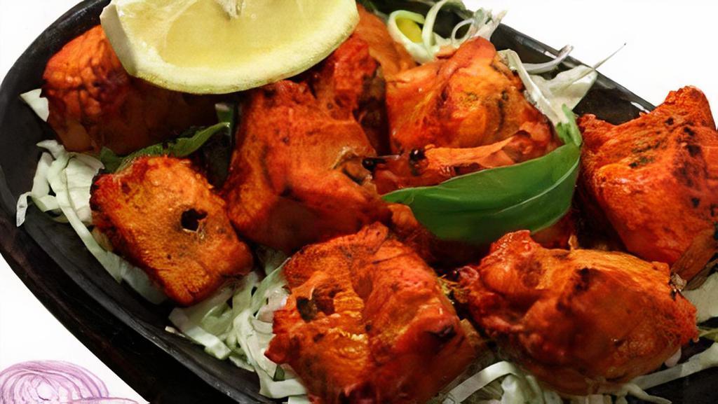 Fish Tandoori · Marinated fish with garlic, herbs, and spices, cooked in clay oven.