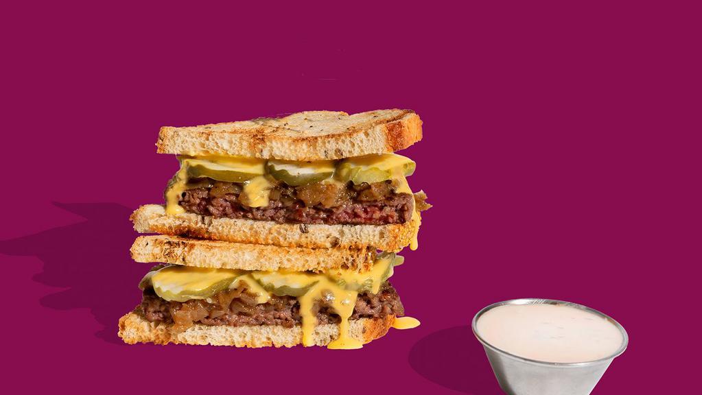 The Impossible™ Pat-B Melt · Our take on a classic patty melt and named after our CEO and Founder, Dr. Pat Brown! This is a must-have Impossible™  taste experience with seared ¼ lb  Impossible™ Burger patty, cola-caramelized onions, plant-based cheese sauce, and dill pickle on grilled sourdough with a side of Shop Sauce for strategic dunking.