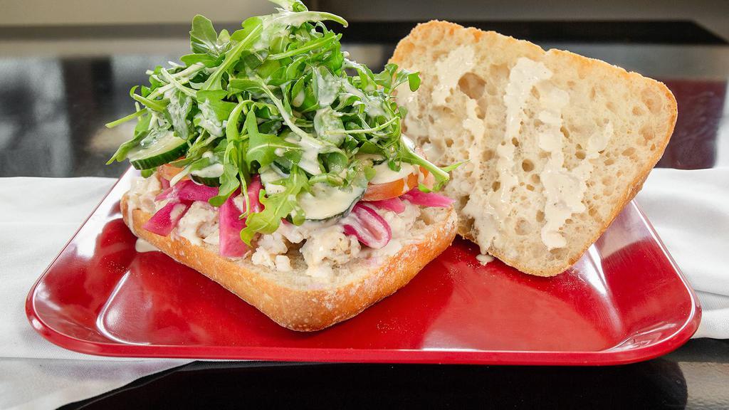 Habibi · Chicken tossed in tahini sauce, cucumber, tomato, arugula, pickled turnips, on a Seeded Roll