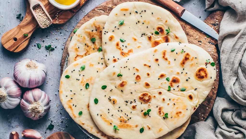 Vegan Garlic Naan · Vegan Flatbread with garlic and coriander garnish. Delicious and good combination with curry and masala.