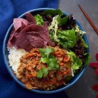 The Cowboy Bowl · Kabayaki beef, blue corn chips, green cabbage, red radish, julienne carrots, red peppers, ci...