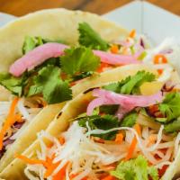 Banh Mi Taco · Corn tortilla topped with Xa-Xiu pork, shredded cabbage mix, pickled carrots-daikon, pickled...