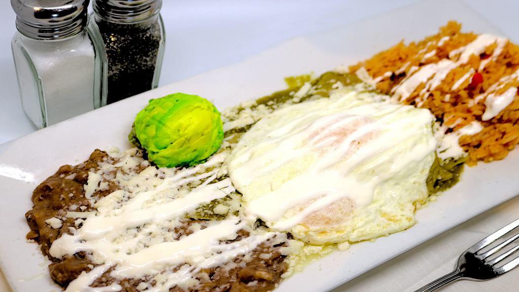 Manuel's Chilaquiles · Manuel's tomatillo sauce simmered with fresh corn tortillas, topped with queso fresco, sour cream and avocado. Served with two eggs, rice and refried beans as garnish.