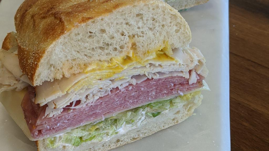 11. The Royal Sandwich · Turkey and pastrami on freshly baked sourdough. Includes lettuce, tomato, red onions, swiss cheese, house spread & mustard choice.
