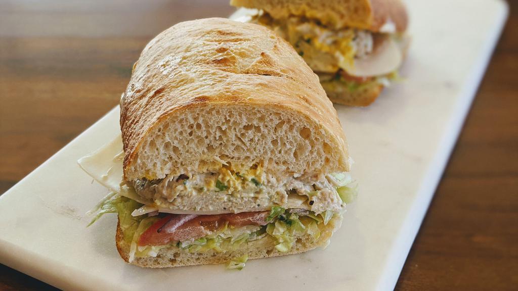 9. The  Albacore Tuna Salad Sandwich · House-made Albacore Tuna Salad on Freshly Baked Sourdough. Includes lettuce, tomato, red onions, swiss cheese, house spread & mustard choice.