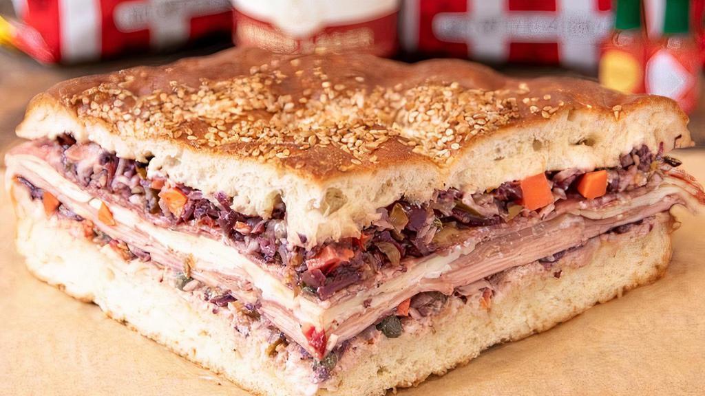 Muffuletta · This aint your traditional muffuletta! Stacked high with Italian mortadella (without pistachios), prosciutto, soppressata, provolone, spicy olive spread and Duke's mayo