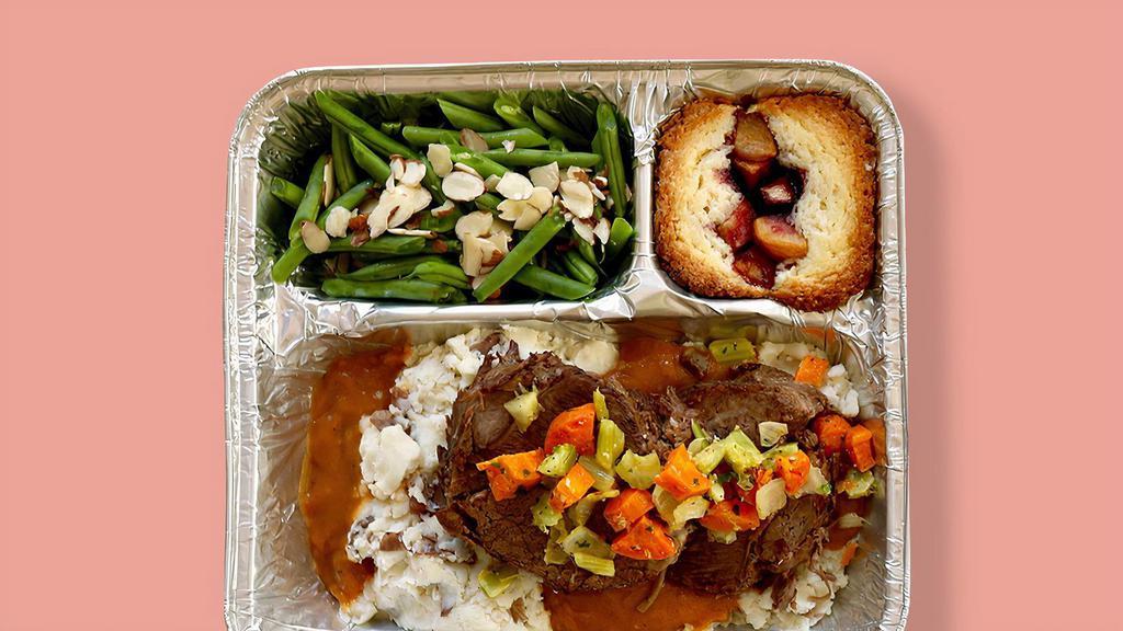 TV Dinner Pot Roast Dinner · Hearty meals made in-house, frozen in retro-style trays, and ready to pop in the oven when you need them. Slow-cooked pot roast with housemade red wine gravy, served with red skin mashed potatoes and green beans + almonds, with a huckleberry-apple cake dessert