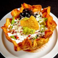 Fish Taco Salad · Large crispy flour tortilla layered with refried beans and topped with romaine lettuce, chee...