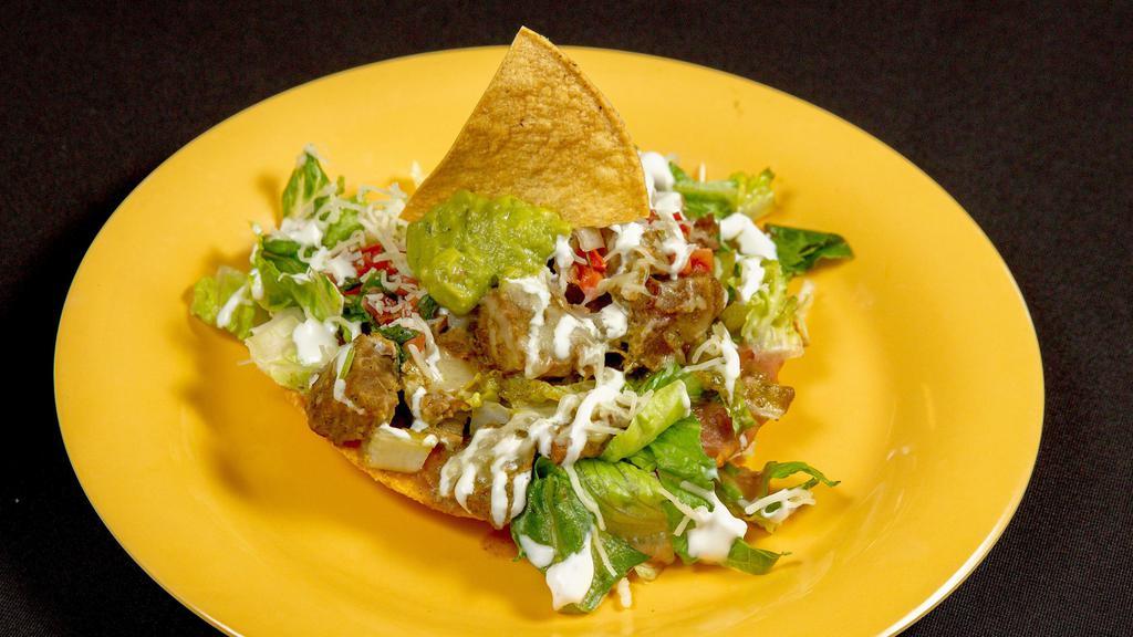 Traditional Meat Tostada · Crispy corn tortilla with refried beans, lettuce, pico de gallo, cheese, cream, guacamole, and your choice of   meat.