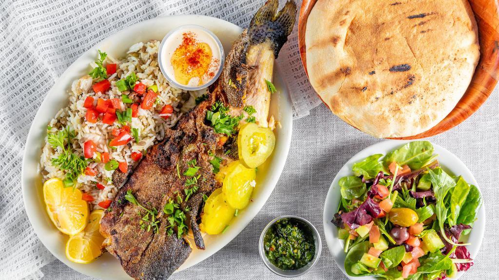 Trout Meal · Whole trout grilled with garlic, lemon, and olive oil served with fries or rice, salad tahini, and pita.