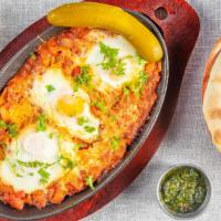 Shakshuka · Poached eggs over tomato sauce with onion, garlic, and red pepper. Served with pita bread an...