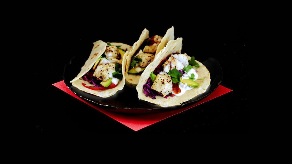 Baja Fish Tacos · Three crispy battered fish with cabbage slaw and crema.