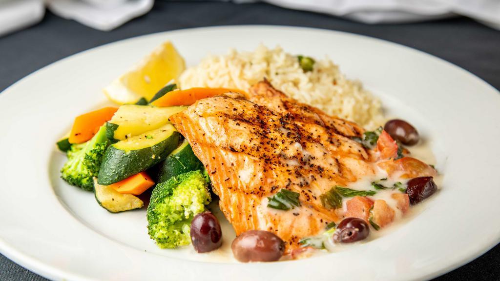 Salmone Siciliana · Grilled fresh salmon with capers, olives, tomatoes, lemon shallot sauce served over rice and vegetables.