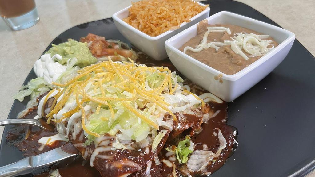 1 Enchilada · Corn tortilla rolled with your choice of meat. Your choice of red, green, or mole salsa. Topped with sour cream, lettuce, cheese, and a side of pico de gallo and guacamole.