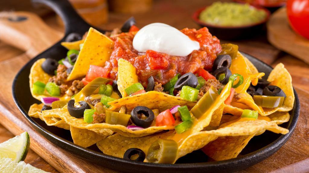 Nachos · Fresh guacamole, melted cheese, pico de gallo, and beans loaded onto warm and crispy tortilla chips and topped with sour cream.