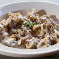 Manti · Homemade ravioli filled with ground beef, onion, spices, topped with garlic yogurt.