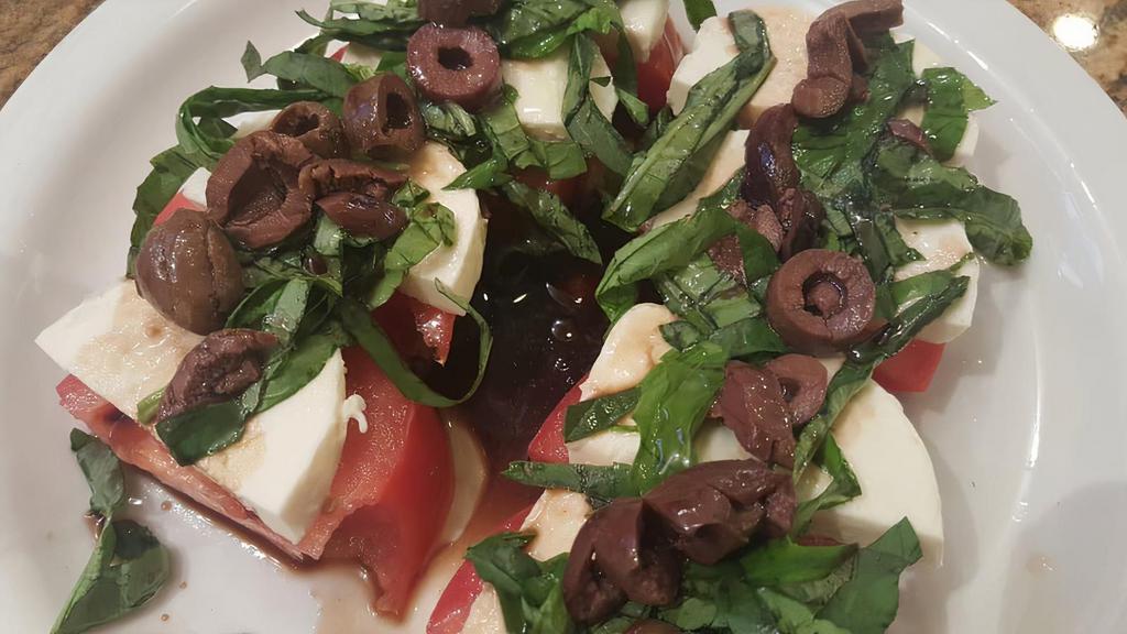 Caprese Salad · Fresh tomato fresh sliced mozzarella cheese shredded basil kalamata olives then topped with oil and vinegar.