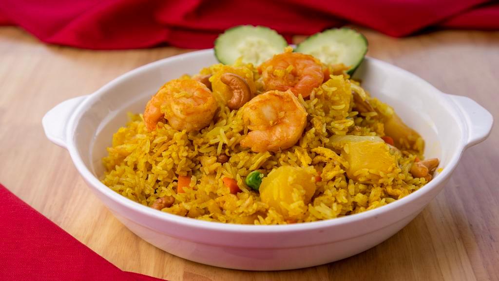 33. Pineapple Fried Rice · Fried rice with prawn, chicken,  egg, pineapple, raisin, cashew nut, onion, pea and carrot.