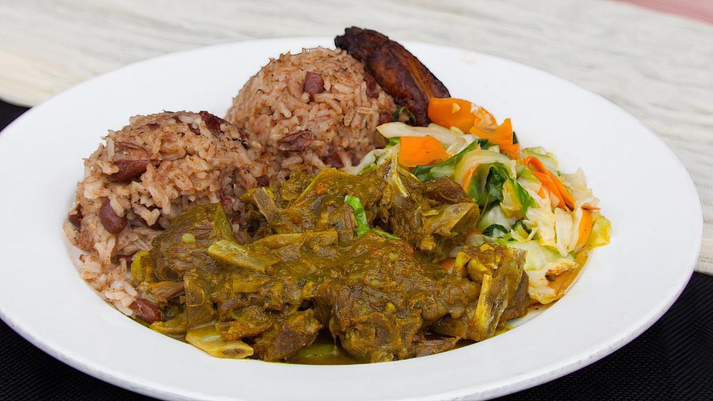 Curried Goat Meal · Tender cubes of succulent goat meat (bone in) marinated with Jamaican curry and spices, rice and peas, sautéed vegetables and plantain
