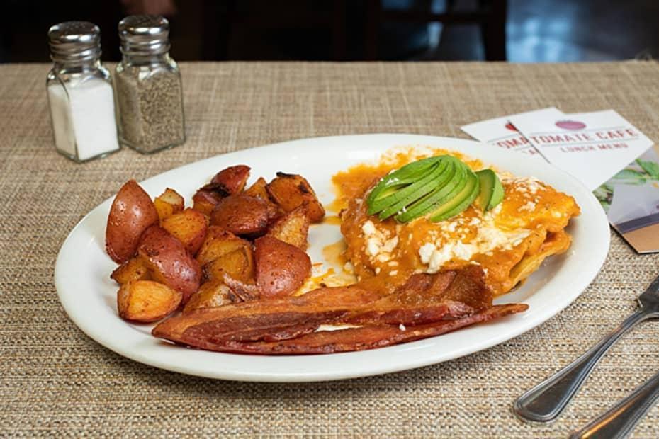Huevos Rancheros* · Eggs, avocado, queso fresco, crispy corn tortillas, black beans topped with fresh red salsa, your choice of meat, and breakfast potatoes