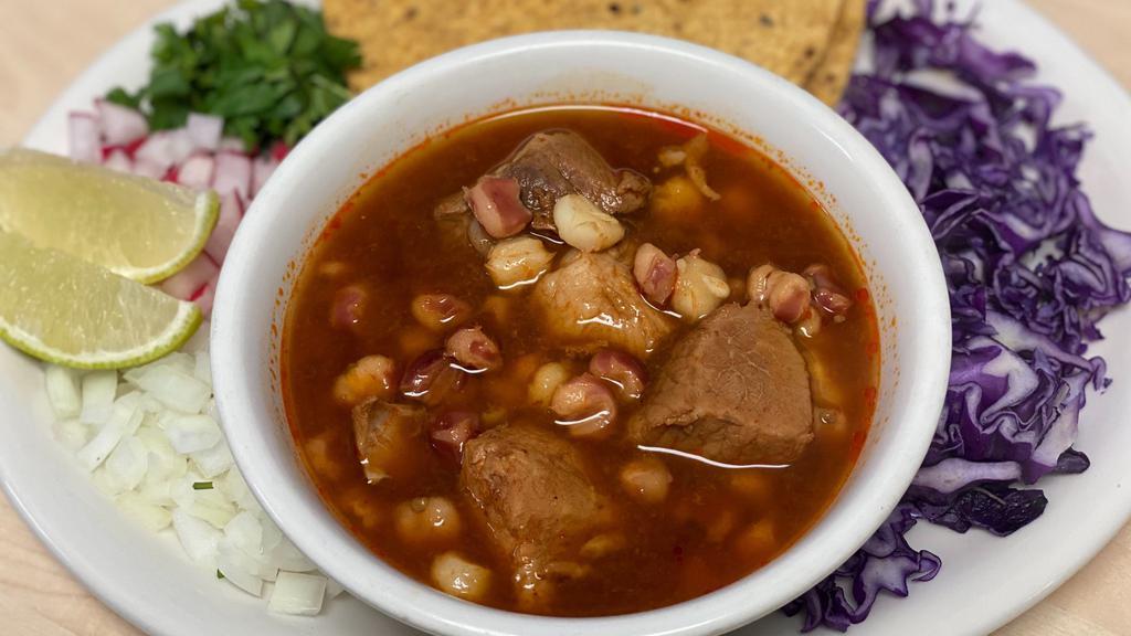 Pozole · Pozole is a traditional Mexican stew that's made with hominy and pork and its garnished with purple cabbage, radishes, onions, cilantro and oregano.