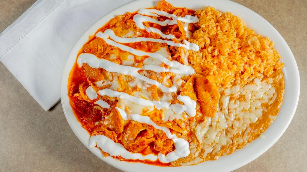 Chilaquiles · Tortilla strips mixed with eggs and onions in a red home style sauce. Topped with melted cheese and sour cream. Served with rice and beans.