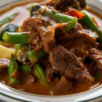 Panang Nua · Our world famous curry! Beef simmered all day with fresh red Thai chilies, green beans, red ...