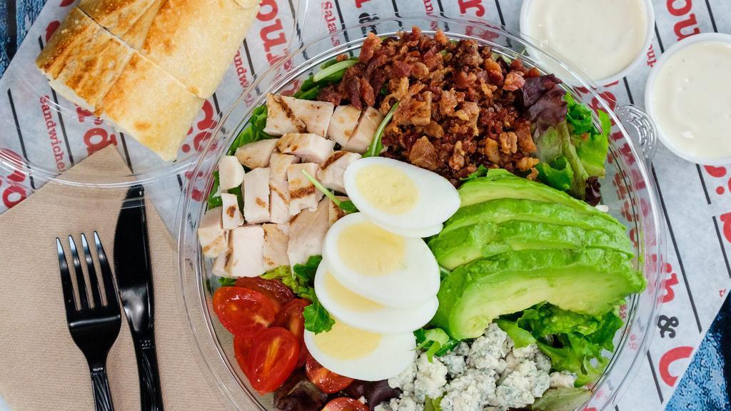 Cobb Salad · Chopped Romaine and Spring Mix, Cherry Tomatoes, Crisp Bacon, Sliced Egg, Avocado, Grilled Chicken, Bleu Cheese Crumbles, and Bleu Cheese Dressing on the side.