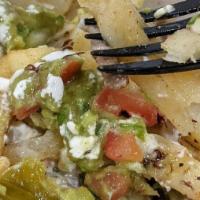 Iguana Nachos · Fresh chips, cheese sauce, choice of beans and meat, guacamole, fresh salsa, sour cream and ...