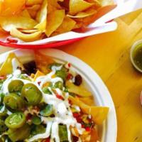 Regular Nachos · A bed of fresh chips covered with cheddar cheese sauce and jalapeños.