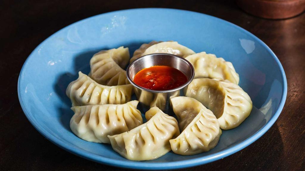 Handmade Steamed Vegetable Momo · Handmade tasty dumplings with your choice of vegetable momo or chicken momo. Served with tomato sauce and special chili sauce on the side.