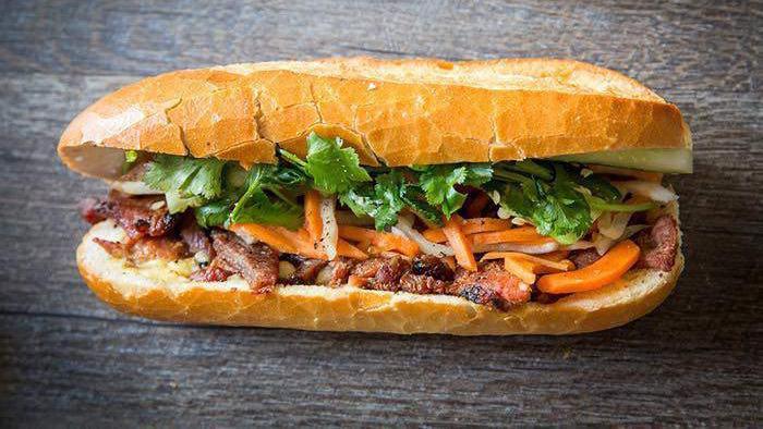 Bánh Mì · The Vietnamese street food classic. Made with in-house marinated lemongrass chicken, duck mousse pâté, homemade pickled daikon radish and carrots, spicy jalapeños, crispy cucumber, fresh cilantro, savory onions, a touch of mayo, all atop a fresh toasted baguette.