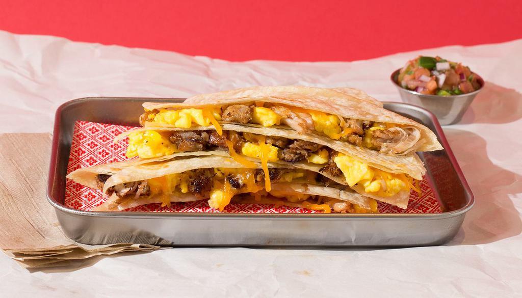 Carnitas Breakfast Quesadilla · Breakfast quesadilla filled with carnitas, eggs, melted cheese, pico de gallo, and served with a side of salsa.