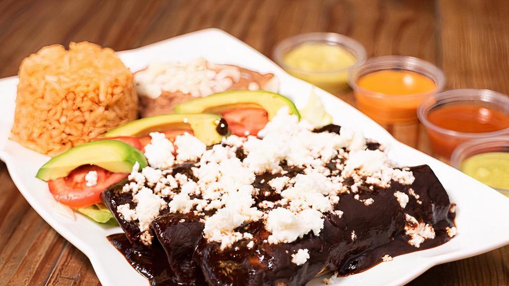 Enchiladas (3) · Your choice of meat in corn tortilla. Rice, beans, avocado, tomato slices, and lettuce on the side. Topped with green sauce or mole sauce.