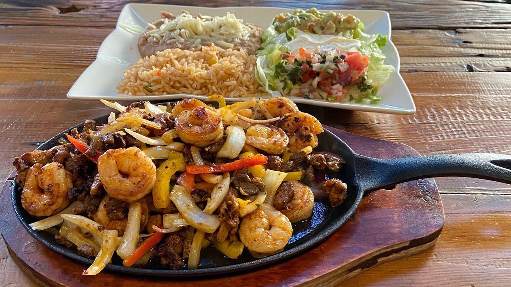 Mixed Fajitas · Steak, Chicken, & Shrimp mixed with bell pepper, onions and mushrooms. Lettuce, pico de gallo, guacamole, sour cream, rice and beans with corn tortillas on the side.