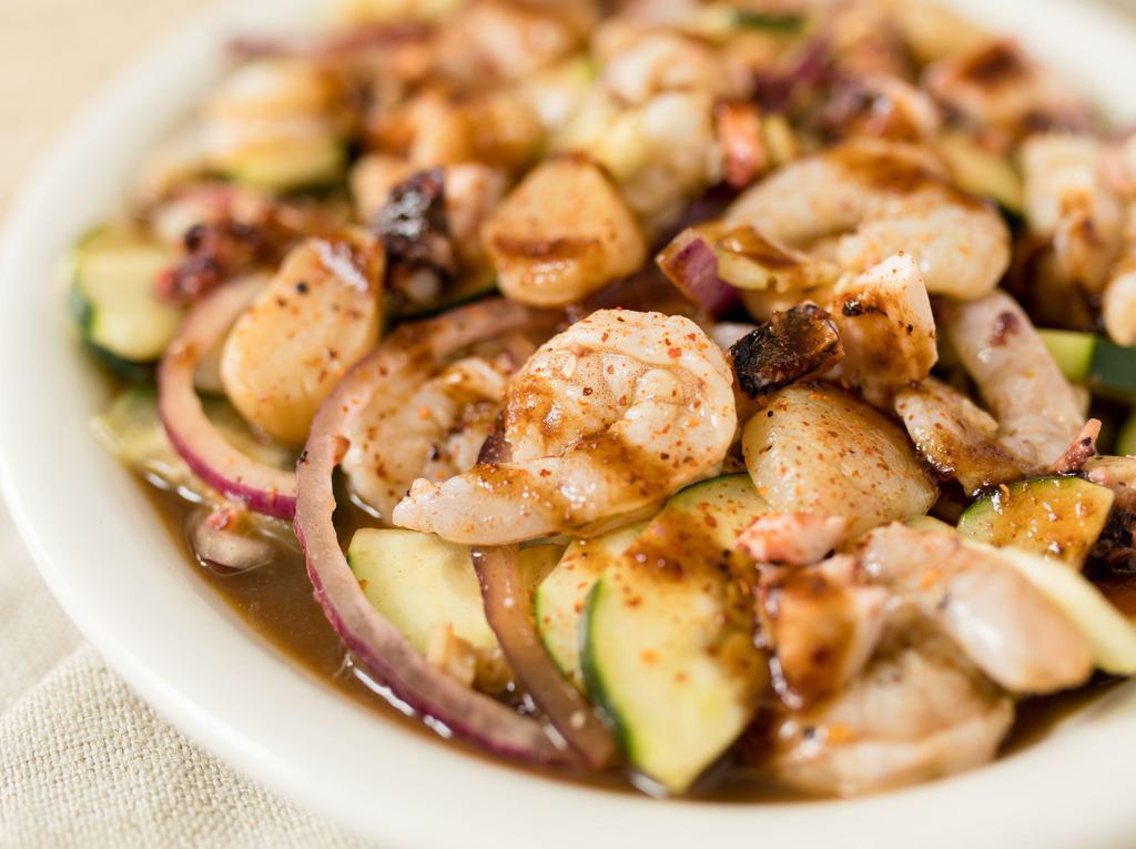 Aguachile Sinaloense · Raw shrimp, scallops, and octopus pickled in lime juice. Tossed with choice of sauce, cucumber and onion, topped with house sauce & chili powder.