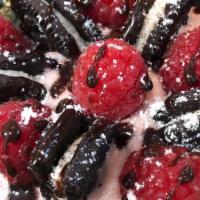 Not Black & White · Raspberry frosting topped with raspberries, ”Oreo” cookies, chocolate sauce and powdered sug...