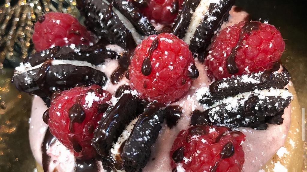 Not Black & White · Raspberry frosting topped with raspberries, ”Oreo” cookies, chocolate sauce and powdered sugar.