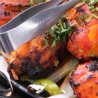 Tandoori Chicken · Grilled chicken marinated in our special tangy indian sauce, served on a skillet