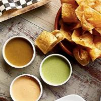Tres Salsas + Chips · Smoked cashew, sikil p’ak (pumpkin seed) habanero + titos salsa with house-made chips.