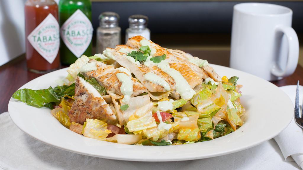 Mexican Grilled Chicken Salad · Grilled chicken, romaine lettuce, tomato, red onion, sweet corn, black beans, cheddar cheese, tortilla strips. Topped with jalapeño sour cream.