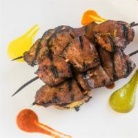 Anticucho De Corazón · Beef heart skewers marinated in aji panca, served with grilled potato, and Peruvian peppers ...