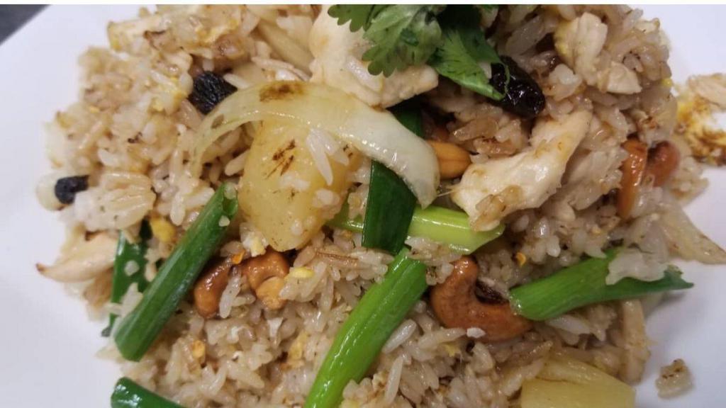 Pineapple Fried Rice · Fried rice with pineapple, cashews, & scallions raisins garnished with cilantro.