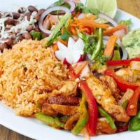 Chile Verde Chicken Dinner · Chicken in green sauce with rice, beans, salad and tortillas.