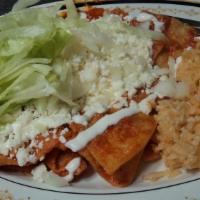 Chilaquiles · Crispy tortilla strips cooked in green, red or pasilla sauce topped with onion, cheese and s...