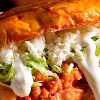 Torta de Pambazo · Potato with chorizo smothered in our own red sauce topped with sour cream, cheese and lettuce.