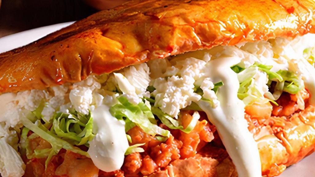 Torta de Pambazo · Potato with chorizo smothered in our own red sauce topped with sour cream, cheese and lettuce.