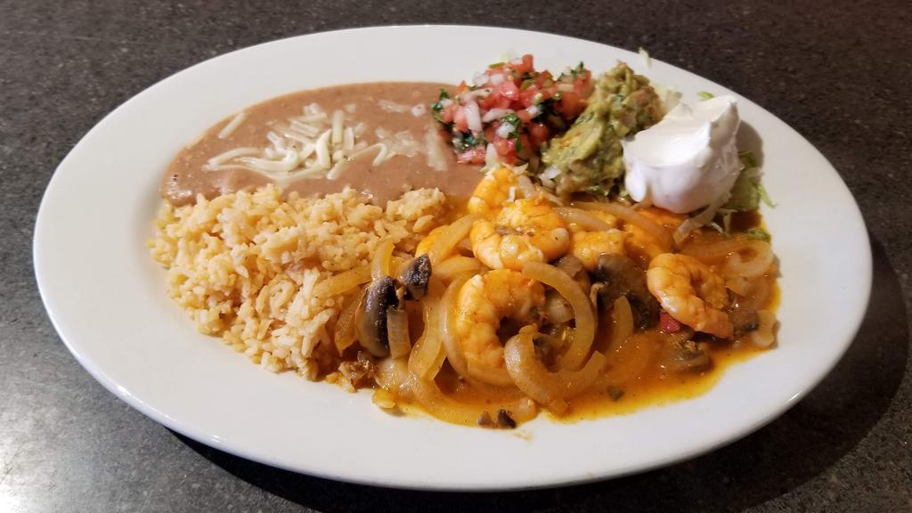 Camarones en Crema Chipotle · Prawns sautéed with mushrooms, onions cheese and chipotle cream sauce. Refried beans and rice, pico de gallo and guacamole.