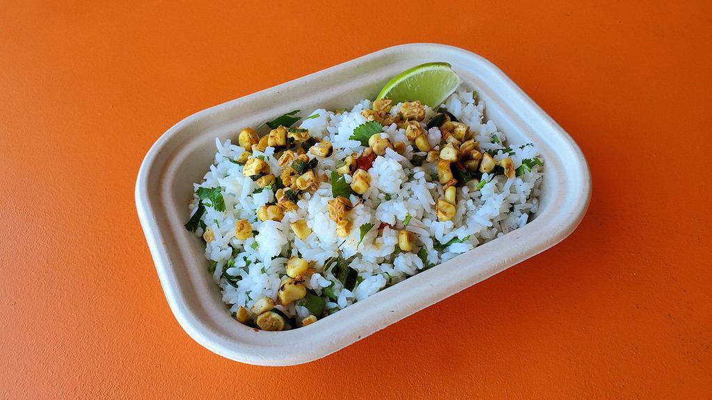 Cilantro Cumin Rice · A Rockin' Delicious accompaniment to our food!  Jasmine rice, cumin, cilantro and garnished with grilled corn salsa and fresh lime.
Vegetarian/Vegan.