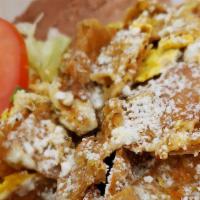 CHILAQUILES · Homemade tortilla chips cooked with eggs and tomato salsa; topped with cheese. Served with S...